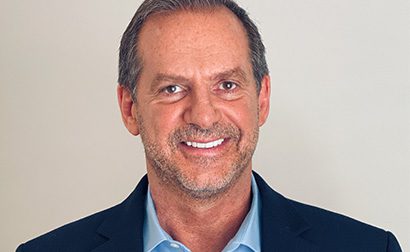 A man with gray hair and a blue shirt.